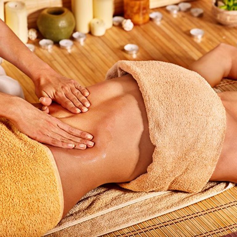 Woman getting massage in bamboo spa
